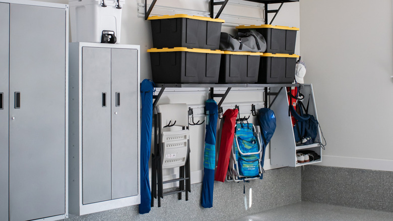 Organized garage with hangers, plastic bins, and wall lockers
