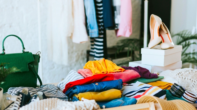 Stack of clothes and shoes and a bag