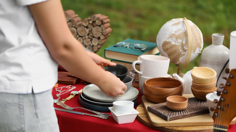 Person grabbing tea set off a garage sale table