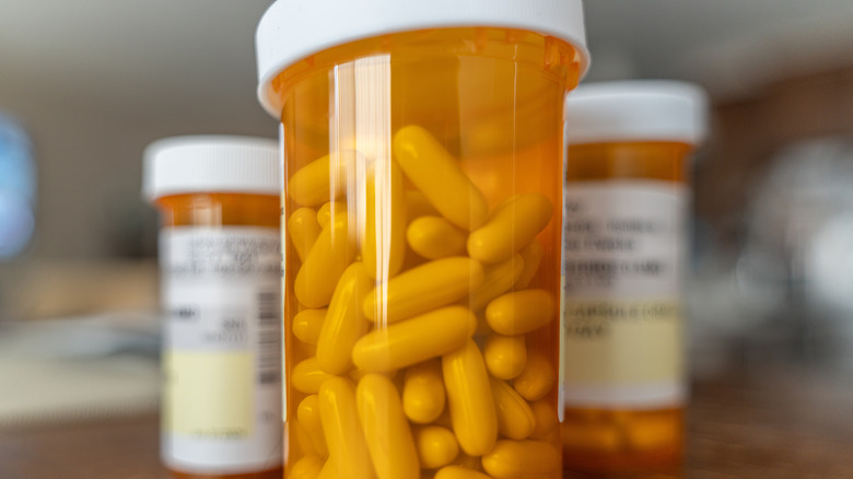 Three prescription medication bottles with pills in them