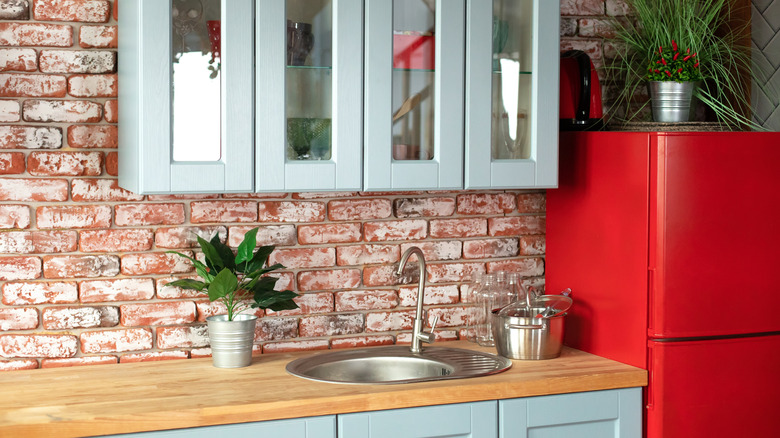 Modern kitchen with blue cabinets and red fridge