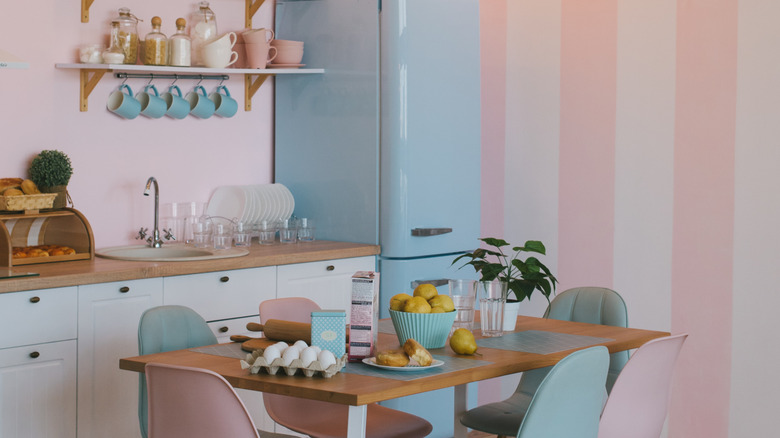 Kitchen with pale pink walls and a blue retro fridge