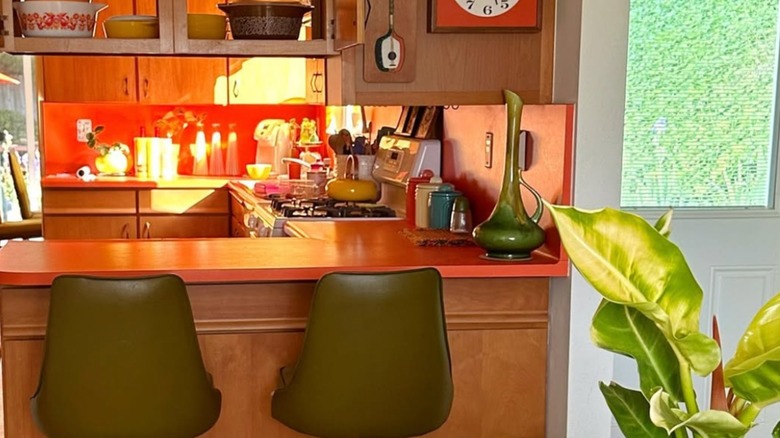 Kitchen with orange counters and olive green stools
