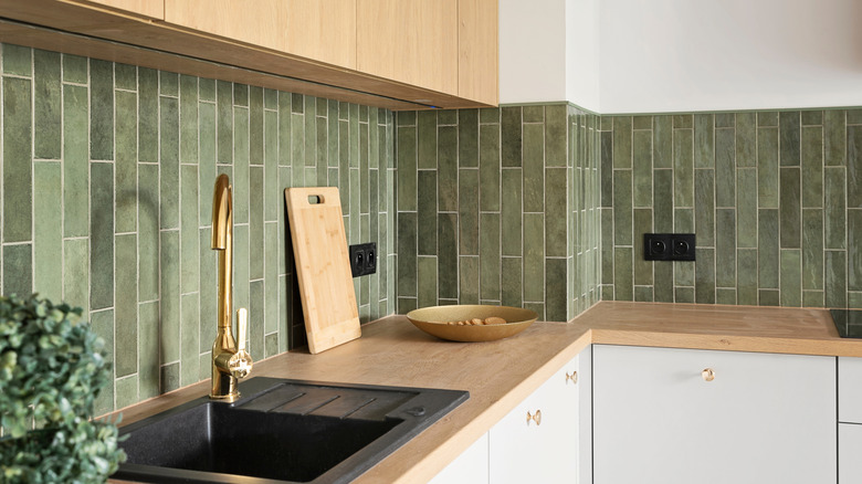 Wood kitchen with brass accents and green tile