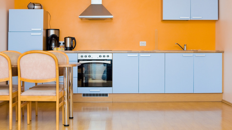 Kitchen with aqua cabinets and orange walls