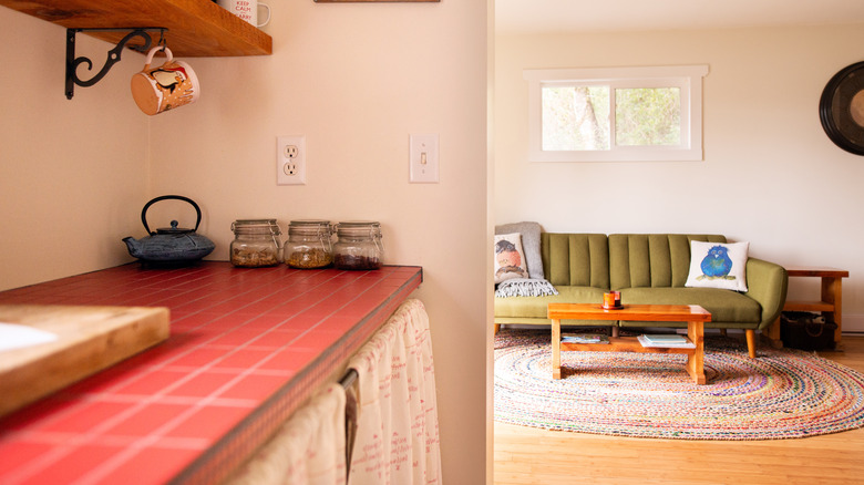 Red brick countertops in a vintage-looking kitchen with green couch