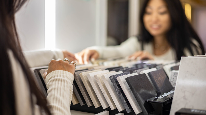 A woman looking at samples of materials for countertops