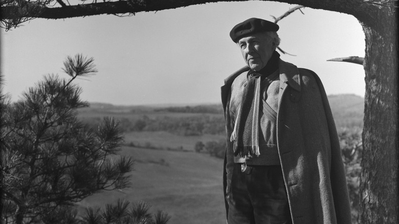 A black and white photo of Frank Lloyd Wright in a garden