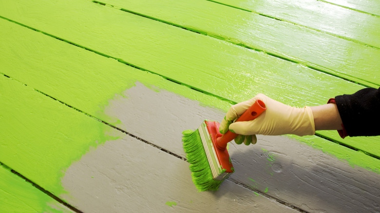 person painting the floor a bright green color