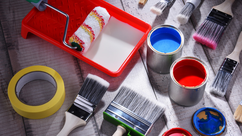 different painting tools on a wooden floor