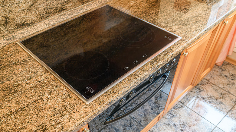 A cooktop on a granite countertop