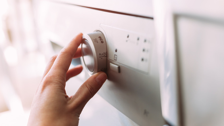 Hand moving the dial on a dishwasher