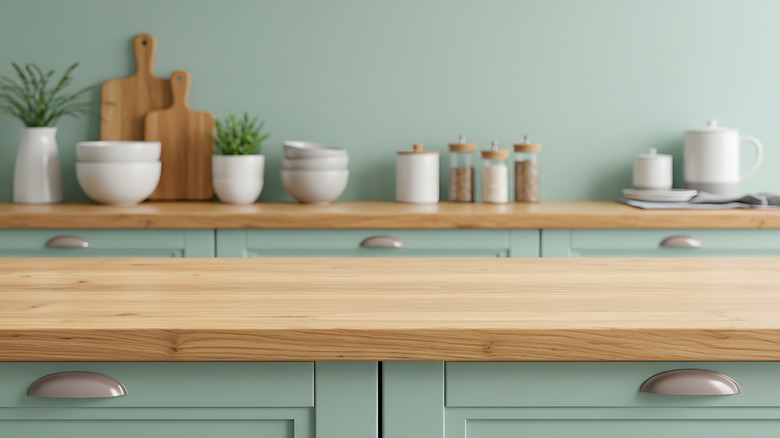 mint green cabinets in the background of a wood countertop
