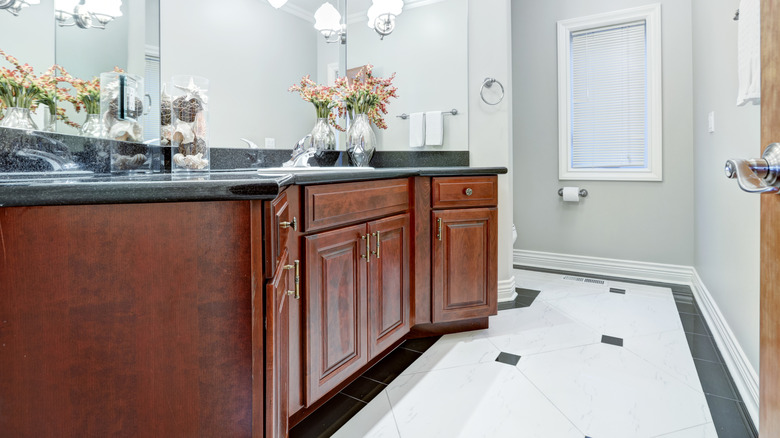 A white bathroom with mahogany vanity cabinets