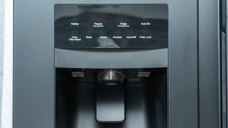 Refrigerator ice maker control panel and dispenser