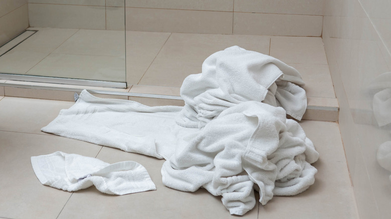 Pile of whitetowels on the floor of bathroom