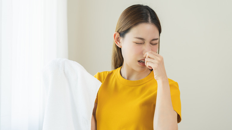 Woman holding a smelly towel