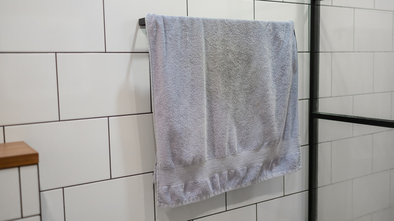 A worn out towel hanging on a towel rack