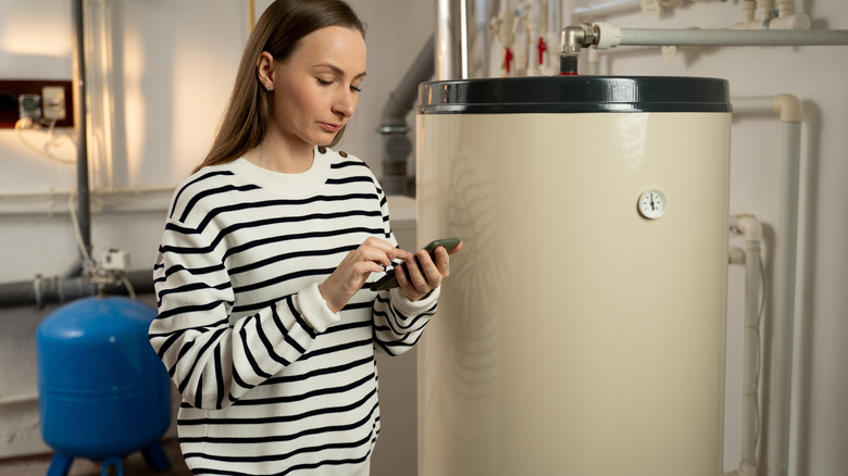 Young woman standing next to boiler in basement