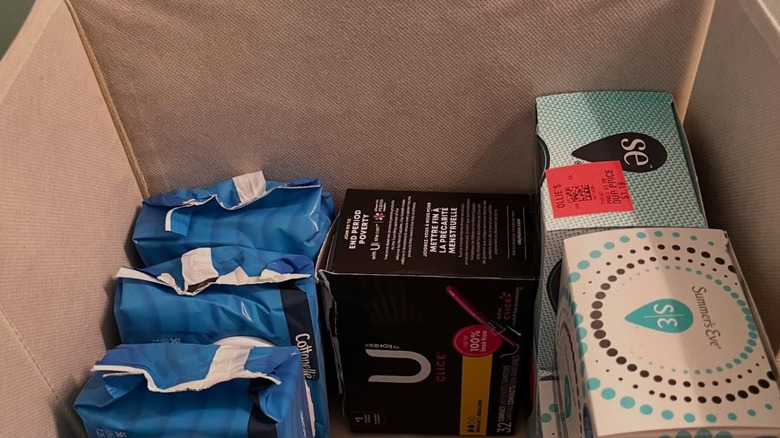 Feminine wipes, tampons, and wet wipes in a fabric storage box