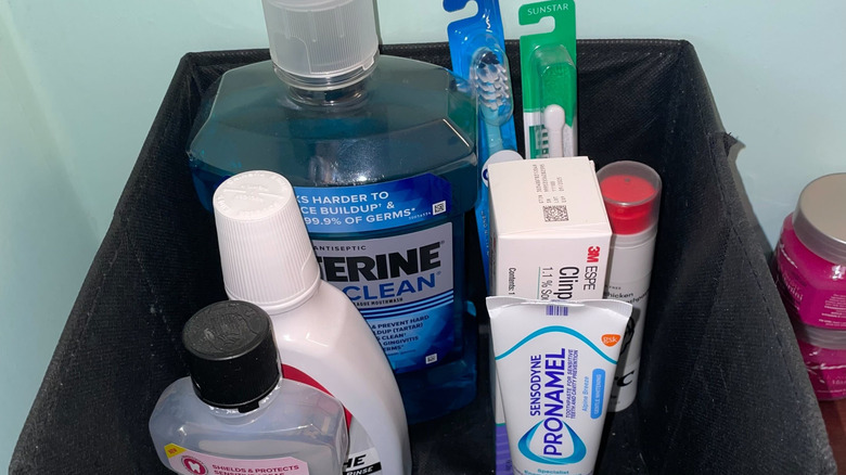Mouthwash, toothpaste, and toothbrushes stored in a fabric bin