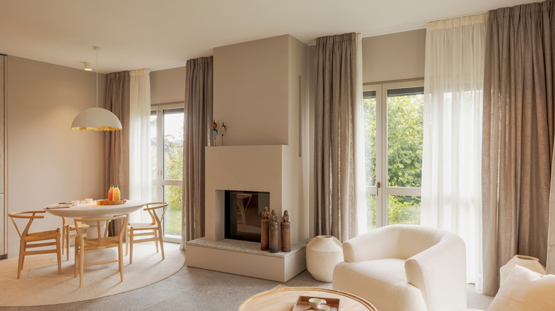 Modern living room with sofa, pillows and white armchair.