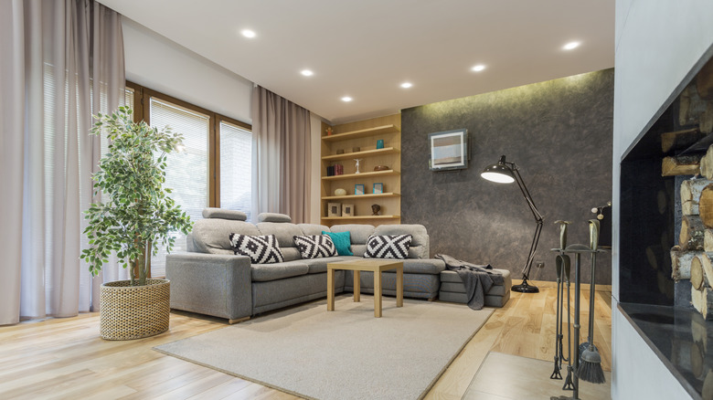 Beige living room with a large corner sofa and a designer floor lamp