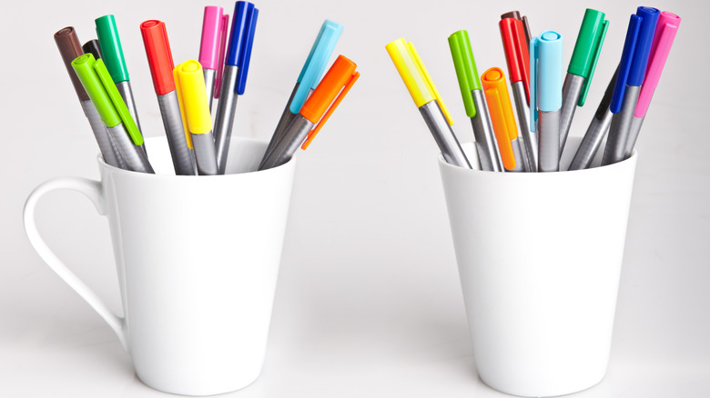 Pens in coffee mugs