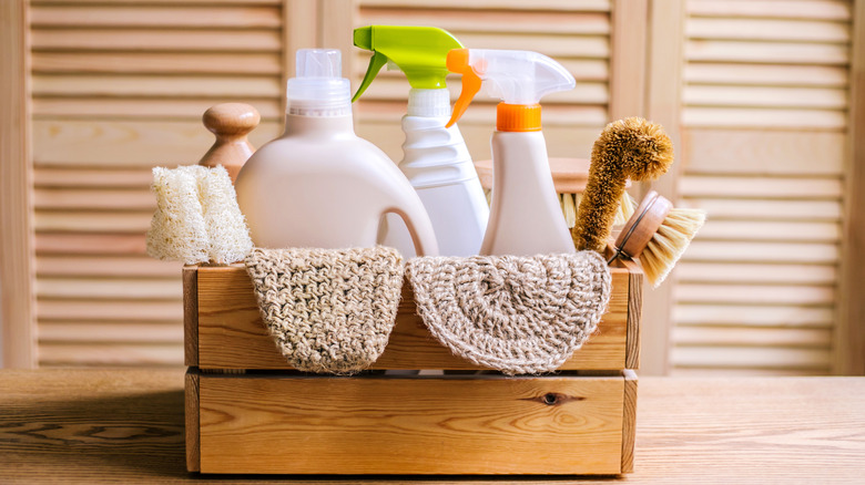 Basket of cleaning products in wooden storage basket on table