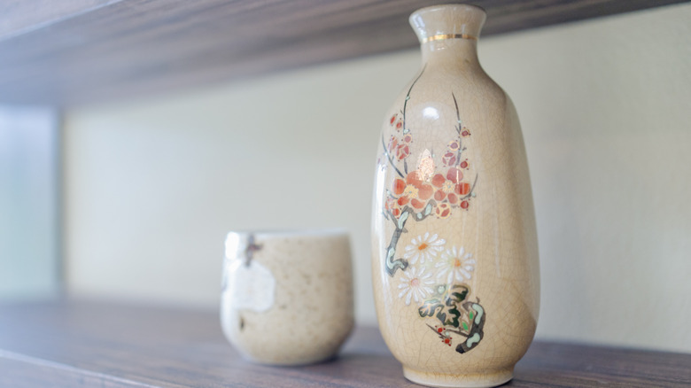 Close up of fragile vase and cup on shelf