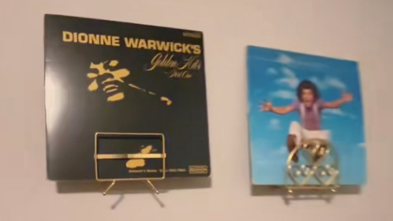 records on a wall held up by napkin holders