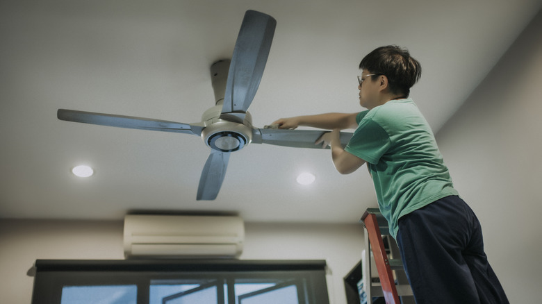 Man wiping down ceiling fan