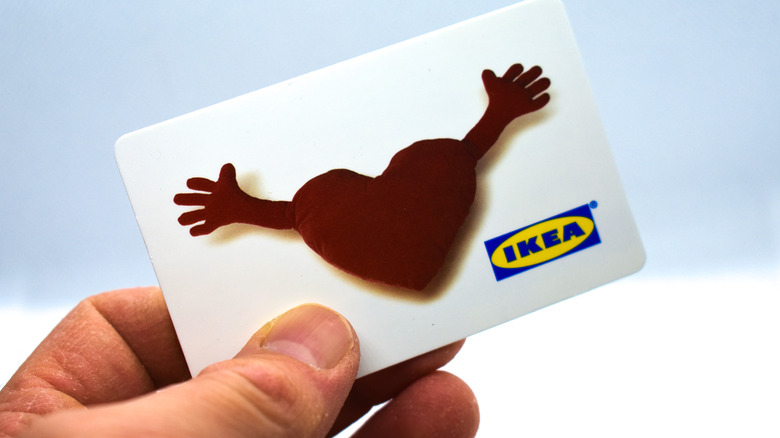 Hand holding an IKEA gift card