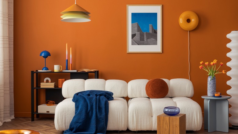 A living room with a small piece of framed art hung on the wall over sofa.