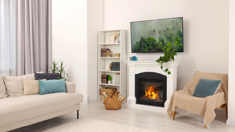 A room with the television mounted over the fireplace.
