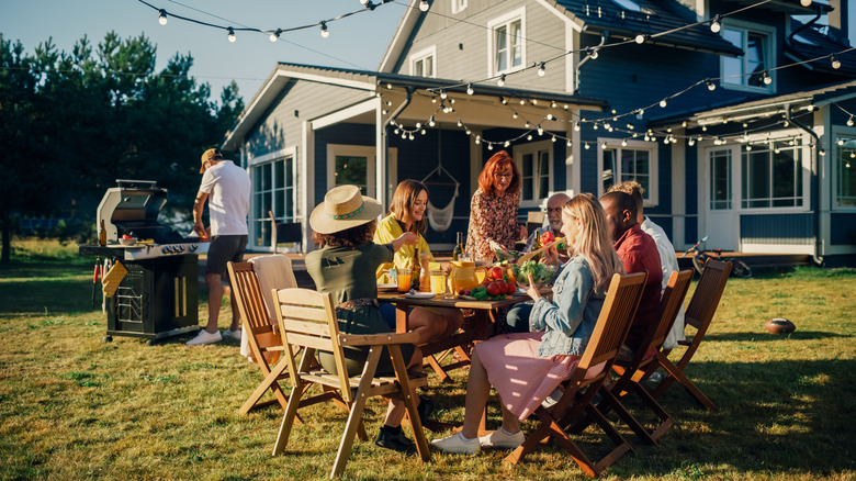 People gathered around a table in a backyard