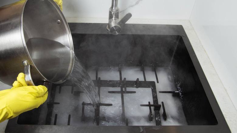 Boiling water being poured over stove grates