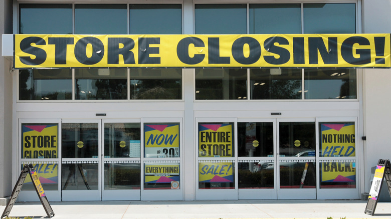 store closing banner and sale signs in front of a building