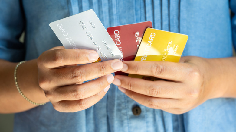person holding several credit cards