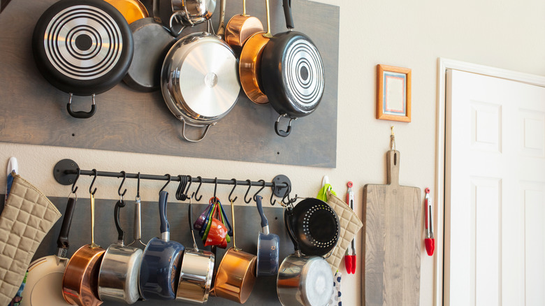 Kitchen wall rack with many pots and pans by door