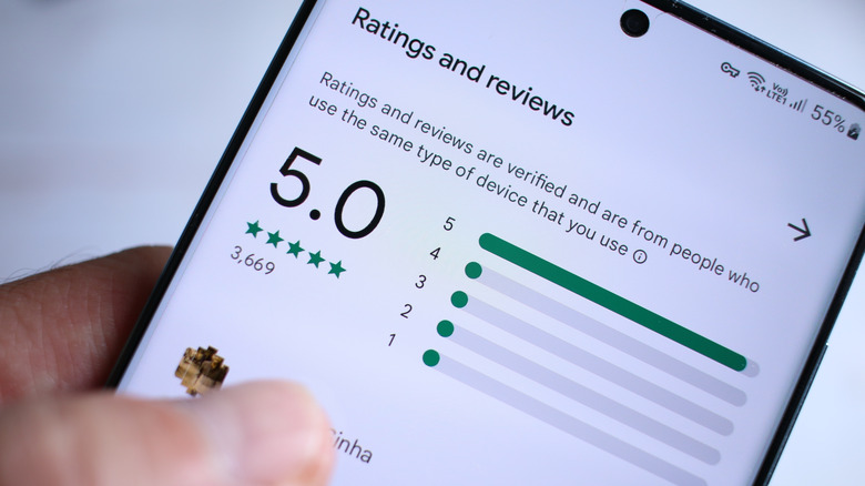 Smart phone on online review screen with five star ratings and reviews