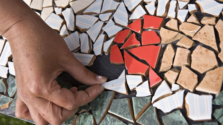 Person adding stones to a mosaic