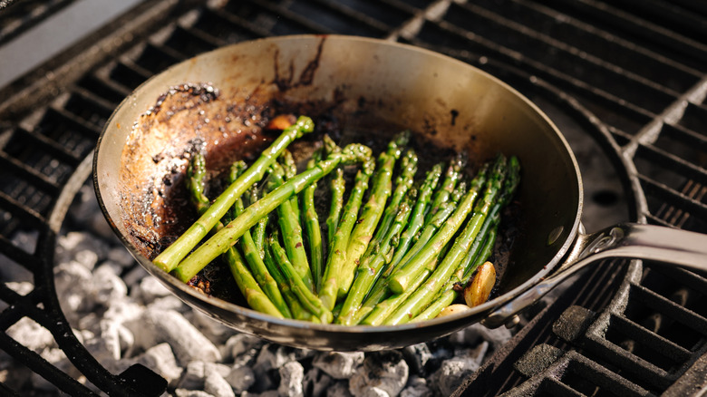 Asparagus cooking in a carbon steel frying pan.