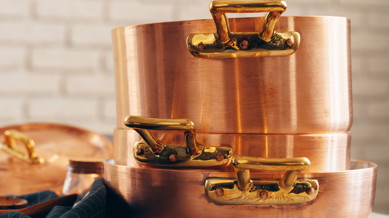 A stack of copper cookware in a kitchen.