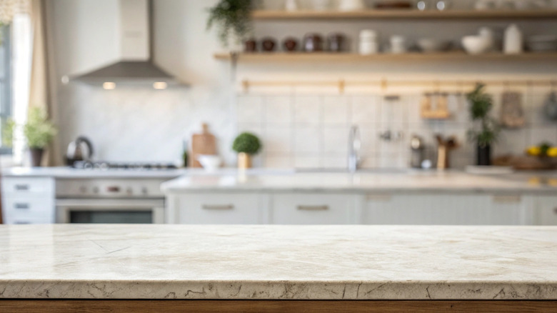 Granite countertop with kitchen out of focus in the background.