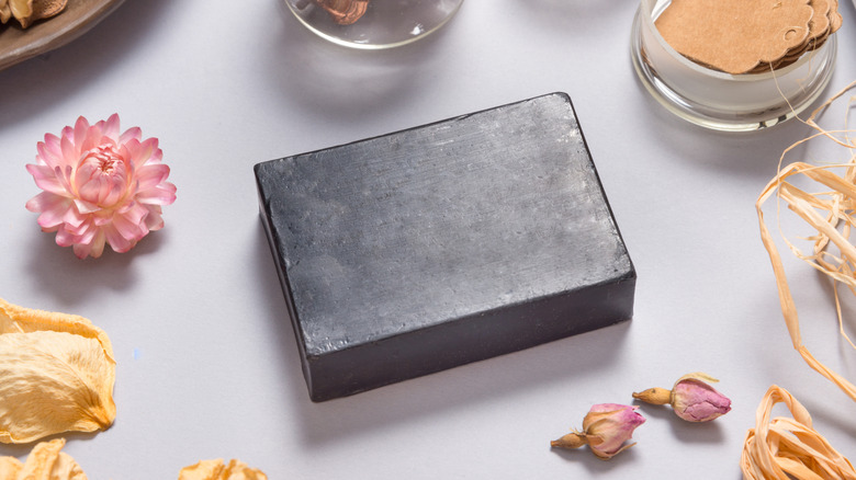 ash soap bar around other soap making supplies and flowers