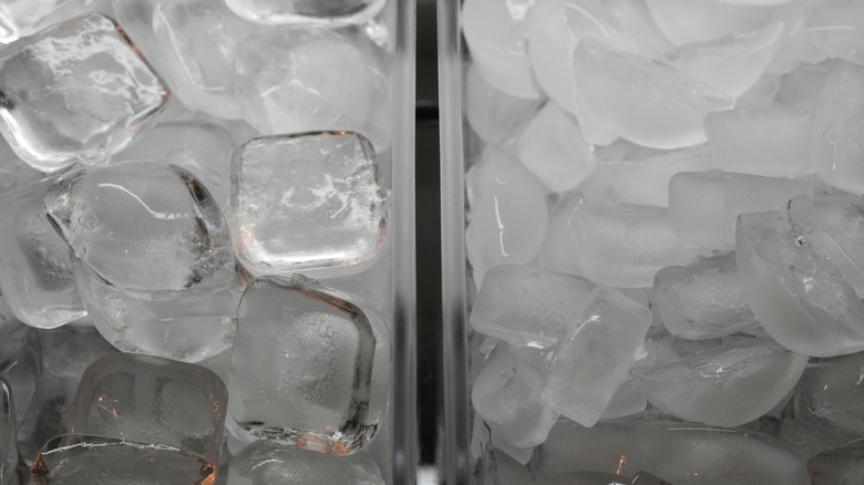 A divided freezer with cubes and rounded pieces of ice