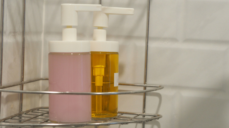 Two hair product bottles sitting in a shower caddy