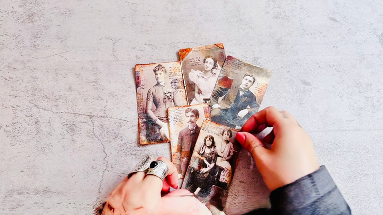 Woman shows off old thrift-store photos she has distressed.