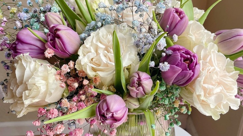 Purple peony tulips, garden roses, and multicolored baby's breath